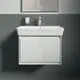 Waschtisch mit integrierter Armatur von Ideal Standard, in Weiß, an einer grauen Wand, ausgestattet mit einem einfachen Waschbecken und einem Spiegel darüber.